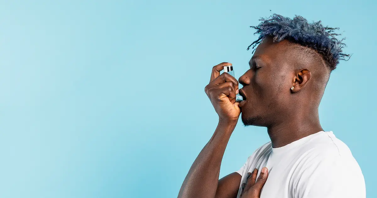Person using an inhaler.