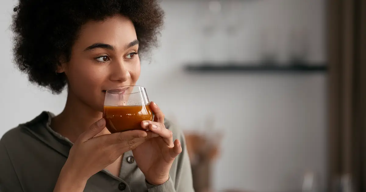 Young African woman sipping a cup of tea.